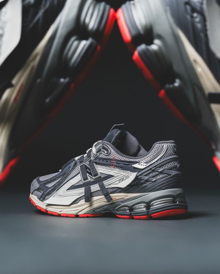 Onderzijde van de New Balance 1906A Slate Grey met N-ERGY demping en robuuste zool. De Drift Red details aan de onderkant maken het design visueel gelaagd en functioneel.