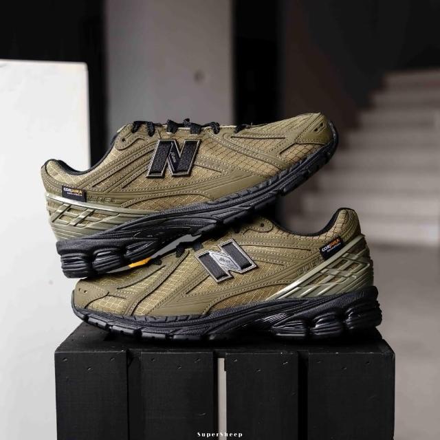 Onderzijde van de New Balance 1906R Camo Olive met robuuste zool en N-ERGY demping. De kleuren in het profiel versterken het rugged, utilitaire uiterlijk van de sneaker.