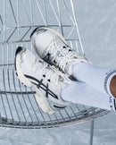 ASICS GEL-Nimbus 9 Cream Black 1201A424-101 in hand met reflecterende zwarte details, off-white basis en zichtbare demping in de hiel

