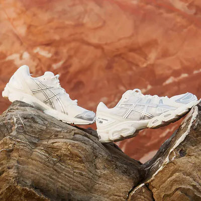 ASICS GEL-Nimbus 9 Wind And Sea White Silver 1203A320-100 in hand met glanzend zilver detail, WDS branding en GEL-demping aan de hiel

