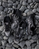 Close-up van de ASICS GT-2160 Above the Clouds Black Gunmetal met metallic gunmetal afwerking, GEL-demping en collab-details

