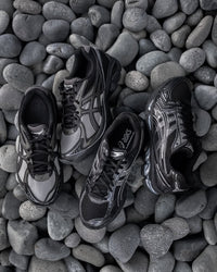 Close-up van de ASICS GT-2160 Above the Clouds Black Gunmetal met metallic gunmetal afwerking, GEL-demping en collab-details

