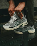 Close-up van de ASICS GT-2160 White Jasper Green 1203A275-106 met GEL-demping, gelaagde constructie en premium afwerking


