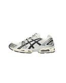 ASICS GEL-Nimbus 9 Cream Black 1201A424-101 zijaanzicht met ademend crème mesh, zwarte tiger stripes en stevige retro zool met GEL-technologie

