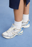 ASICS Cream Pepper gedragen met witte sokken en blauwe rok – stijlvol contrast voor een vrouwelijke retro look

