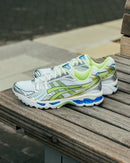 Sneaker in de hand gehouden bij natuurlijk licht – limegroen en zilver springen eruit op het retro hardloopdesign

