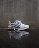 ASICS Gel Kayano 14 White Pure Gold vastgehouden in daglicht met zicht op reflecterende mesh en gouden details – SKU 1202A056 112

