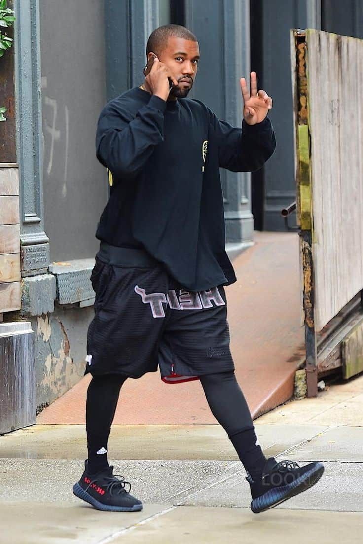 Adidas Yeezy Boost 350 V2 Black Red CP9652 gedragen in een streetwear outfit, waarbij de rode branding contrasteert met de zwarte knit