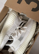 Adidas Yeezy Boost 350 V2 Bone HQ6316 gefotografeerd in de originele Yeezy doos, waarbij de witte sneakers duidelijk naar voren komen