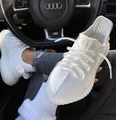 Adidas Yeezy Boost 350 V2 Cream CP9366 gedragen in een auto, witte sneakers in combinatie met casual outfit
