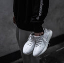 Adidas Yeezy Boost 350 V2 Cream CP9366 gedragen met zwarte broek, waarbij de witte knit upper en zool duidelijk zichtbaar zijn