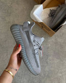 Adidas Yeezy Boost 350 V2 Steel Grey IF3219 boven de originele Yeezy doos gefotografeerd, met focus op de grijze colorway en zool