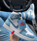 Flatlay van de sneaker met rode Nike OG-box – highlights van het denim materiaal en contrasterende witte zool


