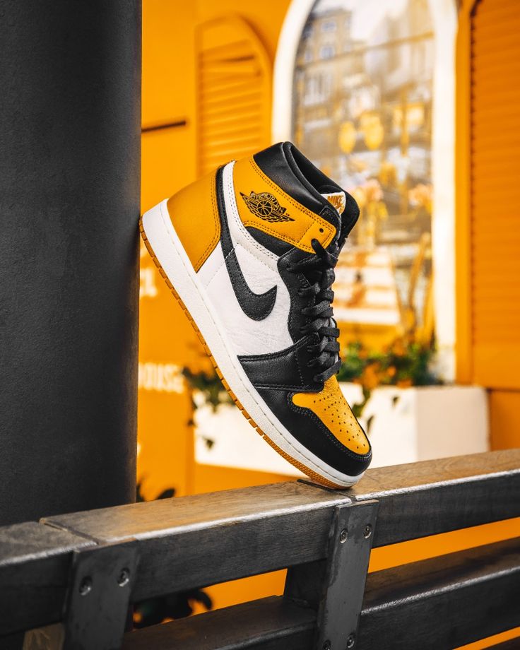 Flatlay van de Jordan 1 Taxi naast de originele zwart-oranje Nike doos – retro vibe met energieke kleurstelling

