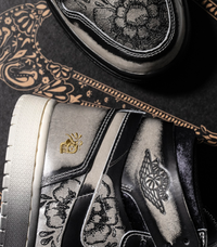 Close-up van de hiel met gouden embroidery en gegraveerde motieven op het bovenwerk – visuele hommage aan Día De Muertos-tradities in een modern silhouet