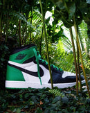 Flatlay van de sneaker naast de klassieke zwart-rode Nike-doos – retro Air Jordan 1 vibe met frisse kleuren

