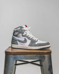 Flatlay van de sneaker en OG-box – de mix van grijs, wit en sail zorgt voor een subtiele maar sterke retro-uitstraling

