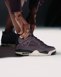 Hoge paars-achtige Nike schoen aan voet met zwarte en witte details en paarse veters