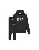 Studiofoto van de Fear of God Essentials IRON 1977 Full Set bestaande uit hoodie en sweatpants in zwarte kleur met 1977 opdruk