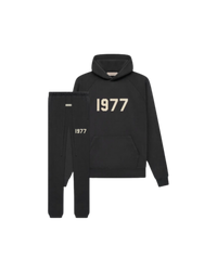 Studiofoto van de Fear of God Essentials IRON 1977 Full Set bestaande uit hoodie en sweatpants in zwarte kleur met 1977 opdruk