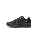 New Balance 1906D Protection Pack Black Leather zijaanzicht met glanzende leren overlays en gerafelde details

