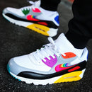 Flatlay van de Be True sneaker met OG-doos en regenboog-details – kleurrijke presentatie van een inclusieve en limited Air Max 90