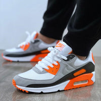 Hyper Orange Air Max 90 on feet met tapered jeans – klassieke Air Max vibes met moderne oranje highlights voor een street-ready look
