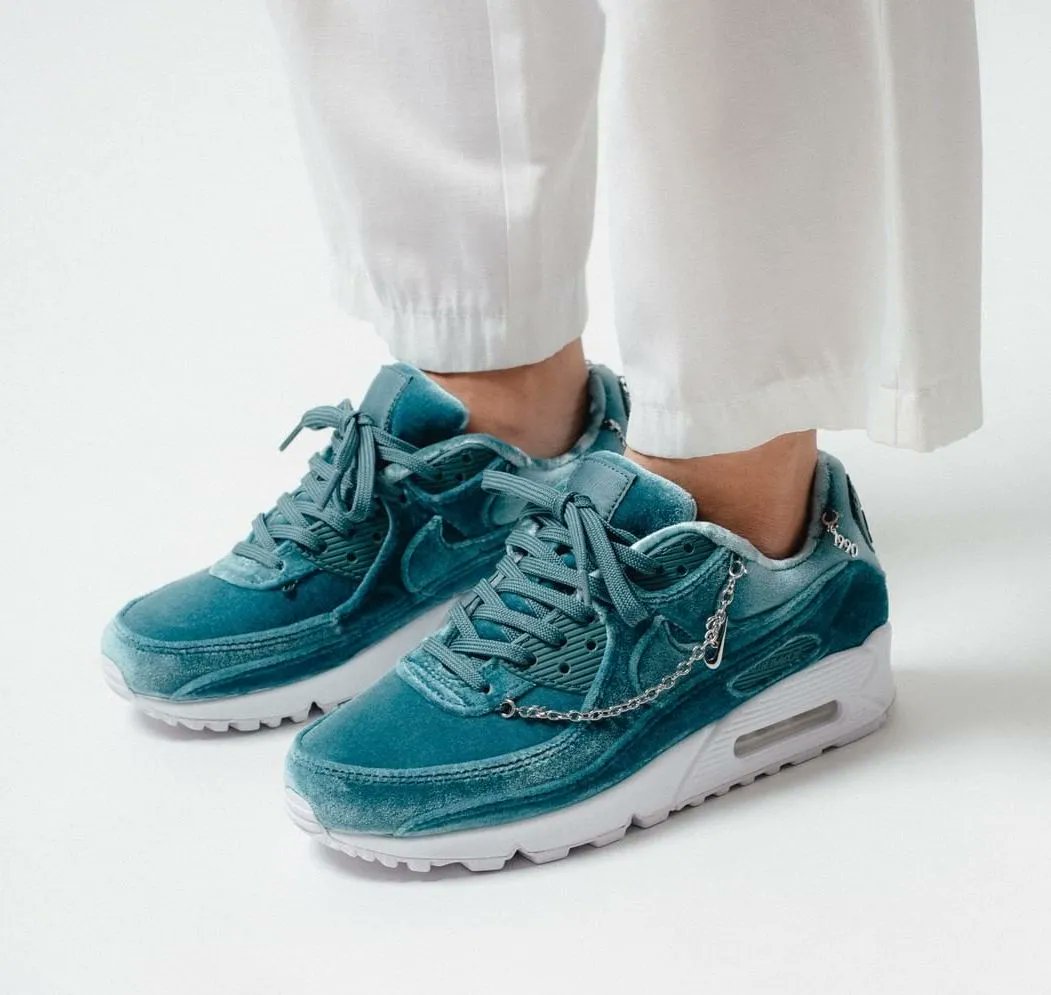 Achteraanzicht van de sneaker met zachtgroene hielstructuur, Nike Air branding en gouden ketting – pastelkleurige details in luxe uitvoering