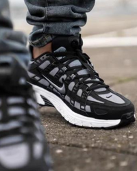 Close-up van de Nike P-6000 Cool Black Grey CD6404-003 met metallic panelen, zwarte mesh textuur en witte midsole, technische afwerking gefotografeerd door Snrkickz.