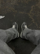 Nike P-6000 Metallic Silver CN0149-001 in paar gefotografeerd op neutrale achtergrond, metallic kleurreflecties en sportieve stijl tonen de klassieke P-6000 spirit van Snrkickz.