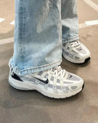 Nike P-6000 Platinum Tint Black in paar gefotografeerd op grijze achtergrond, combinatie van lichtgrijs en zwart benadrukt het tijdloze P-6000 design, exclusieve opname door Snrkickz