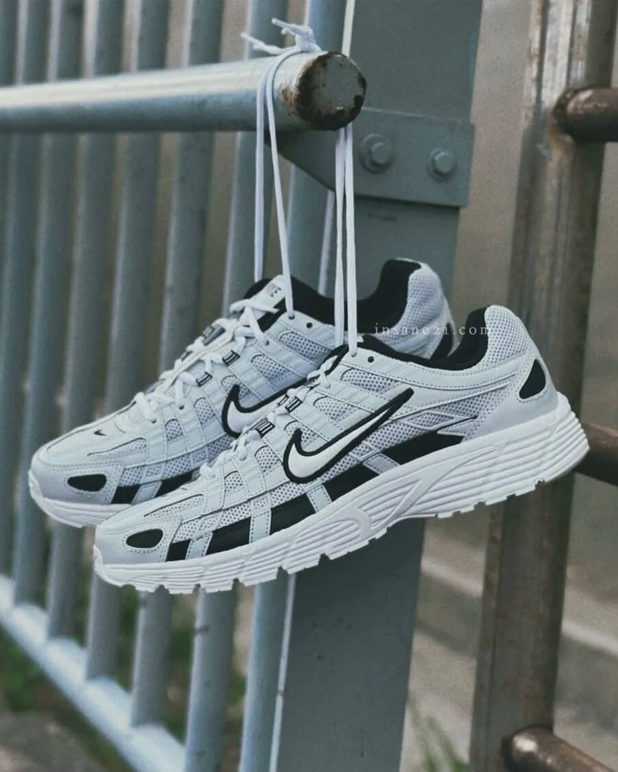 Close-up van de Nike P-6000 Pure Platinum CD6404-006 met metallic zilveren panelen, mesh textuur en witte midsole, verfijnde afwerking en tijdloze stijl, gefotografeerd door Snrkickz.