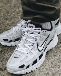 Nike P-6000 Pure Platinum CD6404-006 gedragen met lichte denim in daglicht, glanzende zilvergrijze details en witte accenten zorgen voor een frisse, sportieve look, vastgelegd door Snrkickz.
