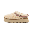 UGG Tazz Slipper Heritage Braid Natural 1143976-NAT met cream sherpa upper, gevlochten rode heritage rand en beige platformzool, gefotografeerd op witte achtergrond door Snrkickz.