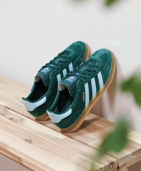 Adidas Gazelle Indoor Collegiate Green – close-up van het zachte Collegiate Green suède met goudkleurig Gazelle-logo en witte leerdetails
