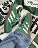 Adidas Handball Spezial Preloved Green White – close-up van Preloved Green suède, wit leerdetail en goudkleurig Spezial-logo