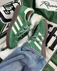 Adidas Handball Spezial Preloved Green White – close-up van Preloved Green suède, wit leerdetail en goudkleurig Spezial-logo