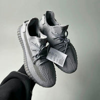Adidas Yeezy Boost 350 V2 Steel Grey IF3219 vastgehouden, waarbij de knit details en originele tags duidelijk zichtbaar zijn