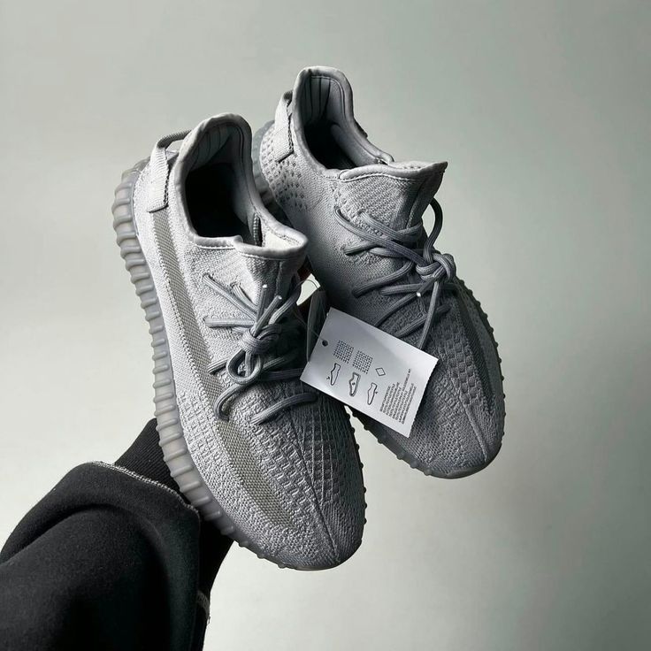 Adidas Yeezy Boost 350 V2 Steel Grey IF3219 vastgehouden, waarbij de knit details en originele tags duidelijk zichtbaar zijn