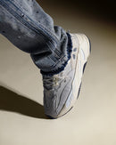 Adidas Yeezy 700 Analog EG7596 on feet gecombineerd met blauwe denim jeans, waarbij de monochrome stijl van de sneaker goed naar voren komt