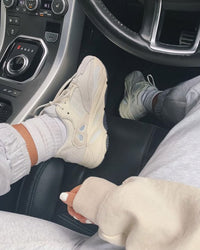 Adidas Yeezy 700 Analog EG7596 gedragen in auto-interieur, met focus op de minimalistische off-white colorway en details van de zool