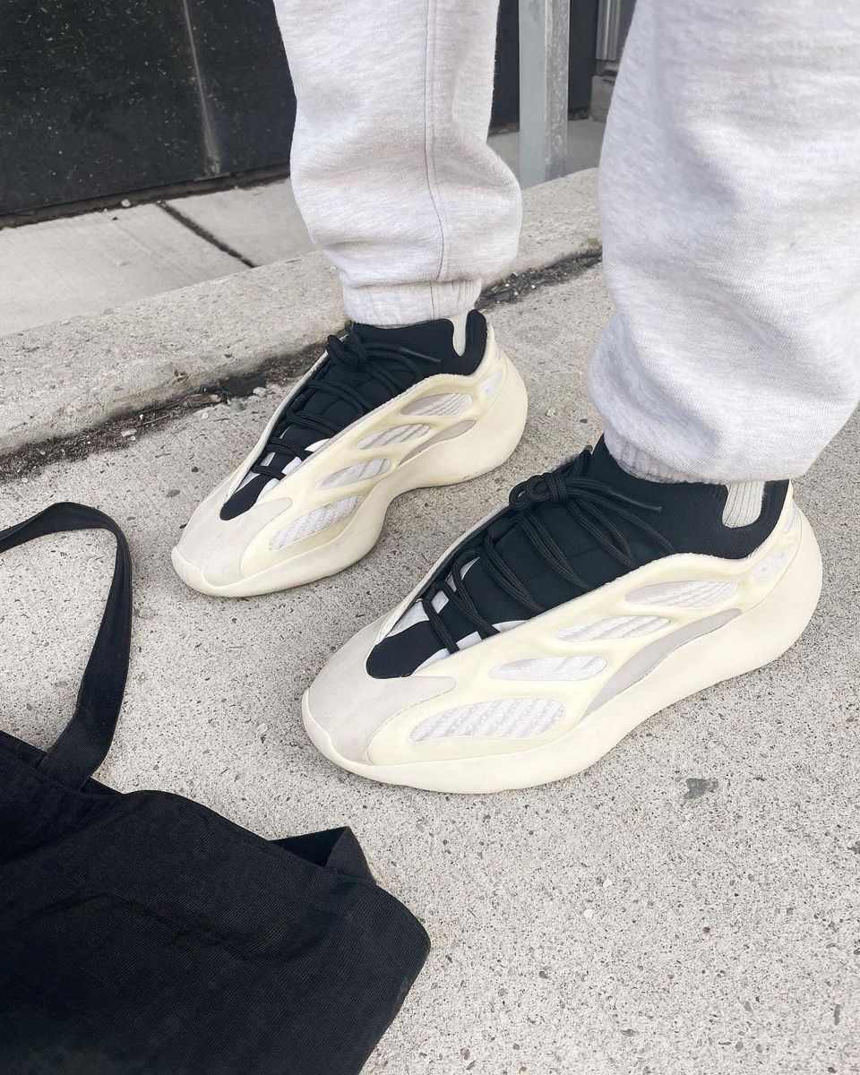 On-foot beeld van de Yeezy Azael gedragen met grijze sweatpants, gefotografeerd op straat met nadruk op glow-cage en futuristisch silhouet