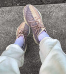 Adidas Yeezy Boost 350 V2 Ash Pearl GY7658 gedragen met lichte broek, waarbij de beige en grijze tinten van de sneaker duidelijk naar voren komen