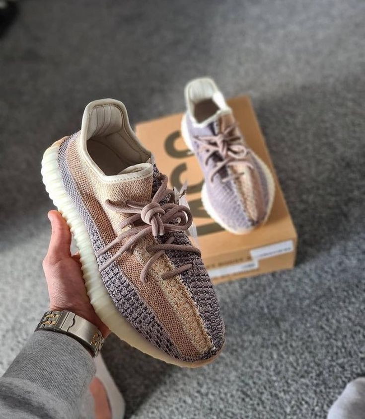 Adidas Yeezy Boost 350 V2 Ash Pearl GY7658 vastgehouden boven originele doos, met zichtbare knit details en tweekleurige upper