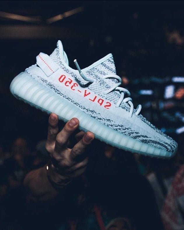 Adidas Yeezy Boost 350 V2 MX Dark Salt ID4811 gedragen tijdens een avondsetting, met focus op de rode SPLY-350 branding en glow van de zool