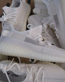 Close-up van de Adidas Yeezy Boost 350 V2 Bone HQ6316 met zichtbare knit textuur en minimalistische witte afwerking