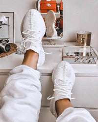 Adidas Yeezy Boost 350 V2 Cream CP9366 gecombineerd met witte joggers in een huiselijke setting