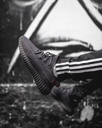Adidas Yeezy Boost 350 V2 Onyx HQ4540 gedragen in een urban setting, met focus op de all-black colorway