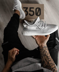 Adidas Yeezy Boost 350 V2 Static EF2905 vastgehouden boven originele Yeezy doos, met zicht op de knit details en zool