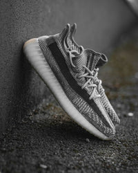 Adidas Yeezy Boost 350 V2 Zyon FZ1267 gefotografeerd vanaf de zijkant op donkere ondergrond, met zicht op de semi-transparante zool
